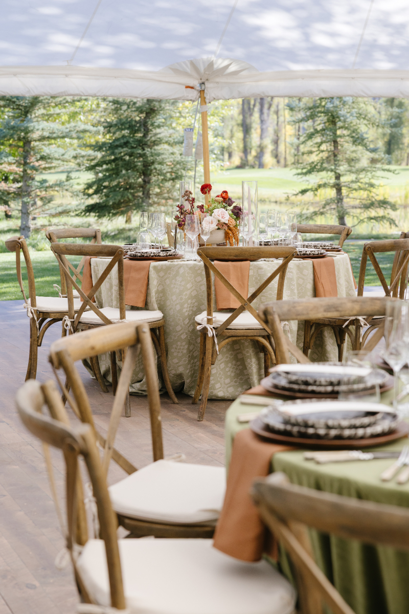 Elegant wedding tablescapes with floral centerpiece, vintage plate setting, and rustic wooden table that over looks Snake River Overlook at the Grand Teton