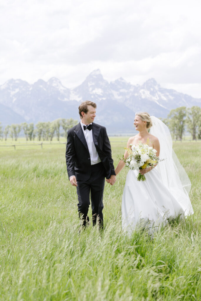 Bride and Groom looking at each other and holding hands after their mountain elopement.
