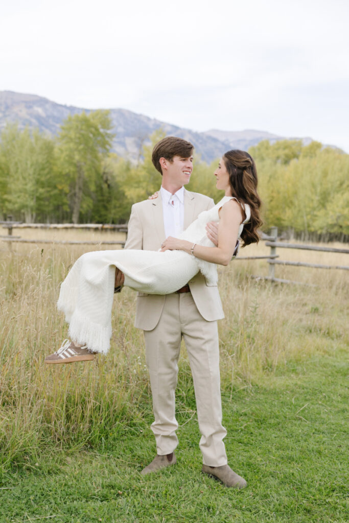 Groom holding wife while they look at each other eyes ready for a mountain elopement.