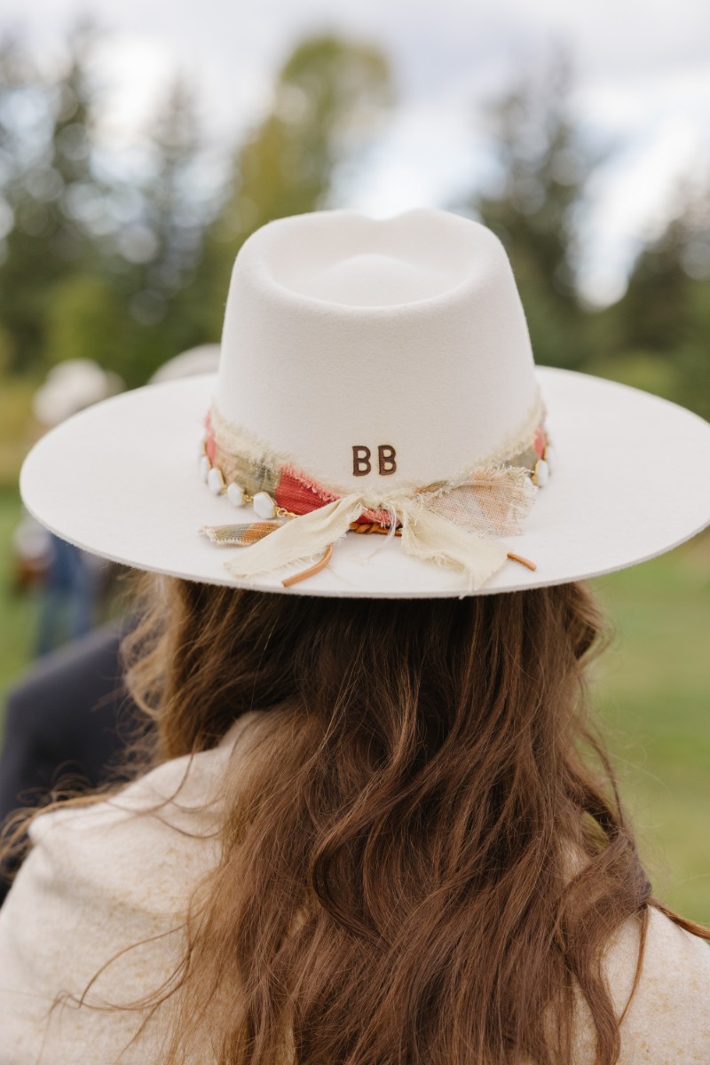 Guest wearing a custom western hat at a Jackson Hole ranch wedding