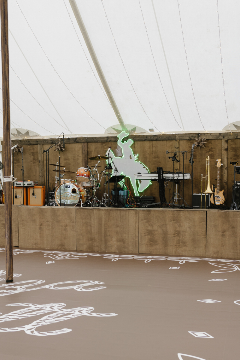 Live band setup with western decor inside a wedding reception tent