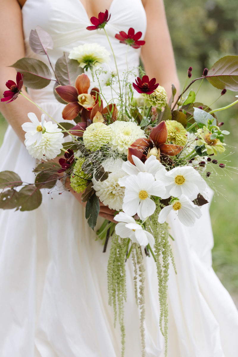 Bride holding a wildflower bouquet with soft neutral tones at a Jackson Hole dude ranch wedding