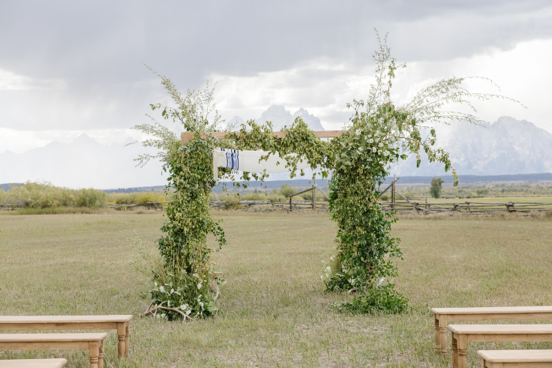 Outdoor wedding ceremony arch with greenery and Teton mountain views in Jackson Hole
