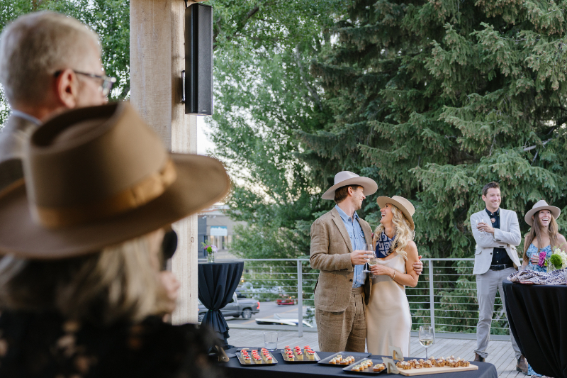 Couple smiling together at a rooftop welcome party