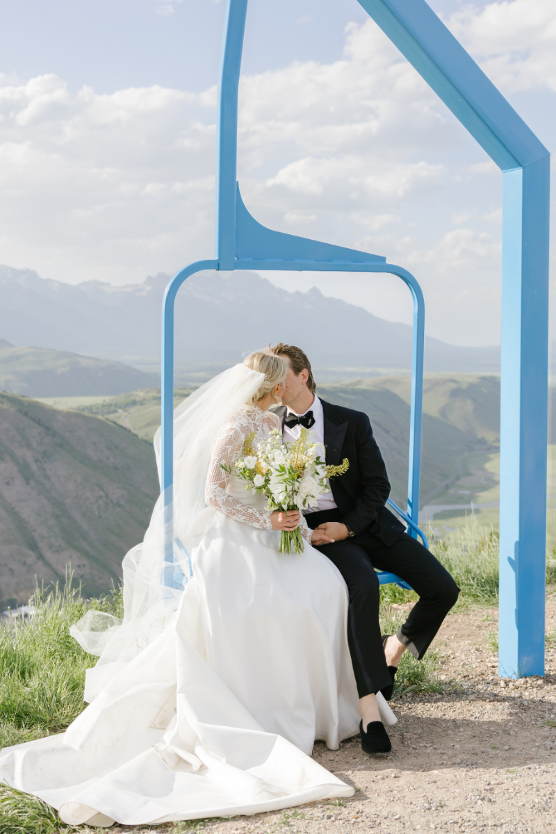 Bride and groom kissing on a chairlift during a Snow King Mountain wedding portrait session