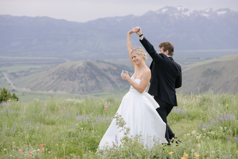 Wife being twirled by her husband while on top of the Snow king mountain wedding.