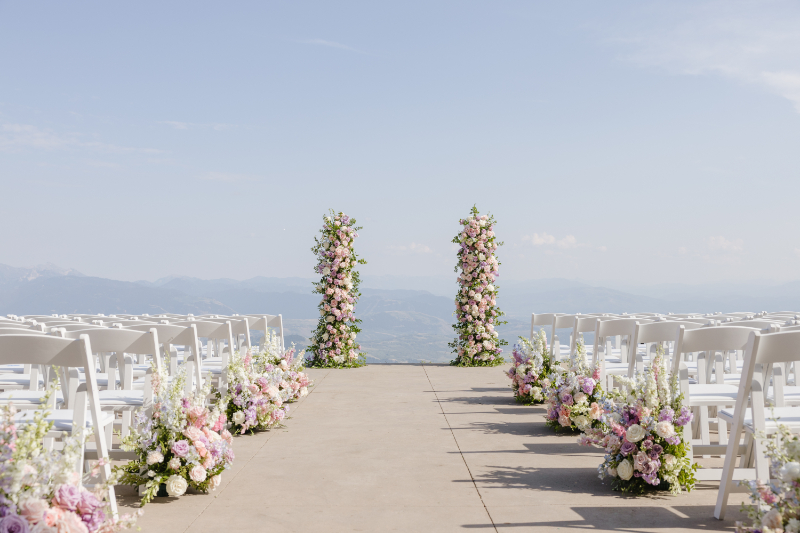 Elegant mountain wedding ceremony setup in Jackson Hole with pastel floral arrangements, open skies, and breathtaking mountain landscapes.