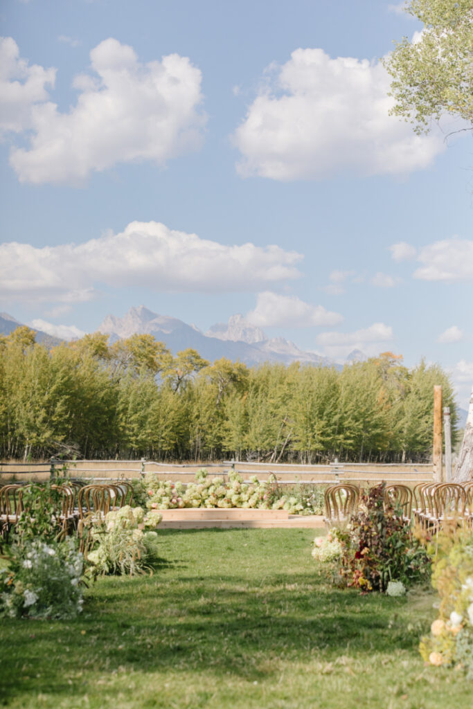 Destination wedding in the mountains ceremony setup with floral aisle design and sweeping Grand Teton views in Jackson Hole.