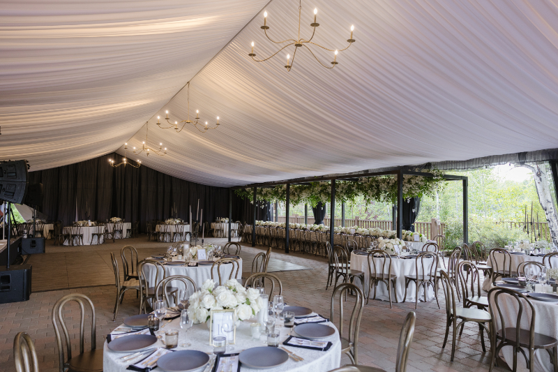 Elegant indoor reception space for a destination wedding in the mountains with draped ceilings, candlelight chandeliers, and refined floral tablescapes in Jackson Hole.