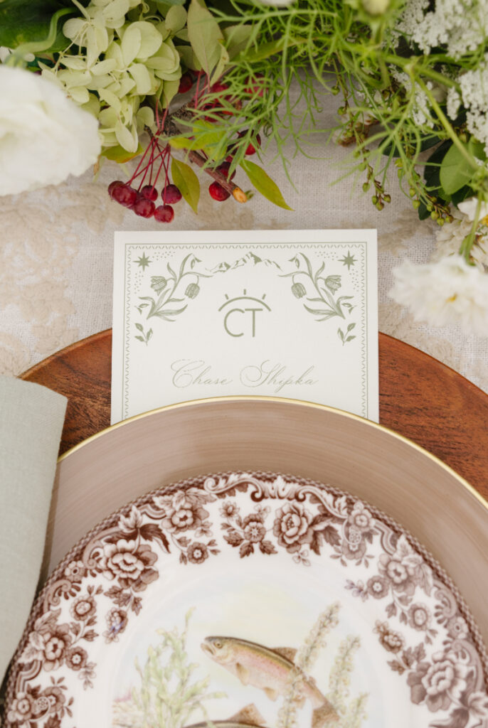 Elegant wedding place setting with floral details and custom name card at reception