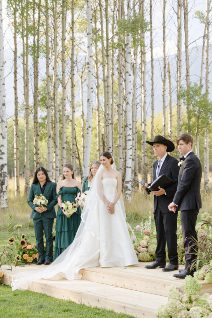 Outdoor wedding ceremony in Jackson Hole with bride, groom, and bridal party among aspen trees