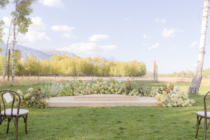 Outdoor wedding ceremony setup with floral arrangements and mountain views in Jackson Hole