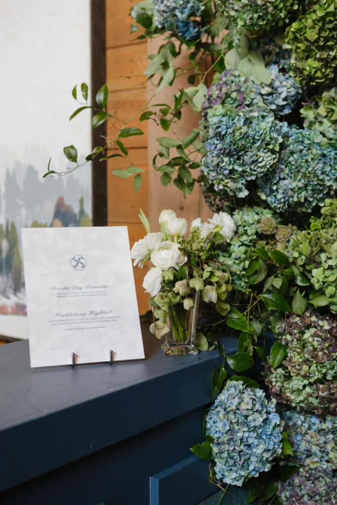 Refined wedding weekend cocktail display with lush hydrangea florals and custom signature drinks at a Jackson Hole celebration.
