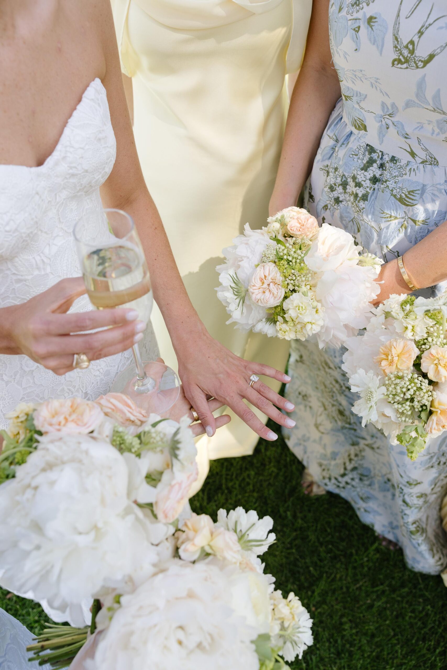 Bride showing her ring after the ceremony and is surrounded by bridal bouquets and bridesmaid