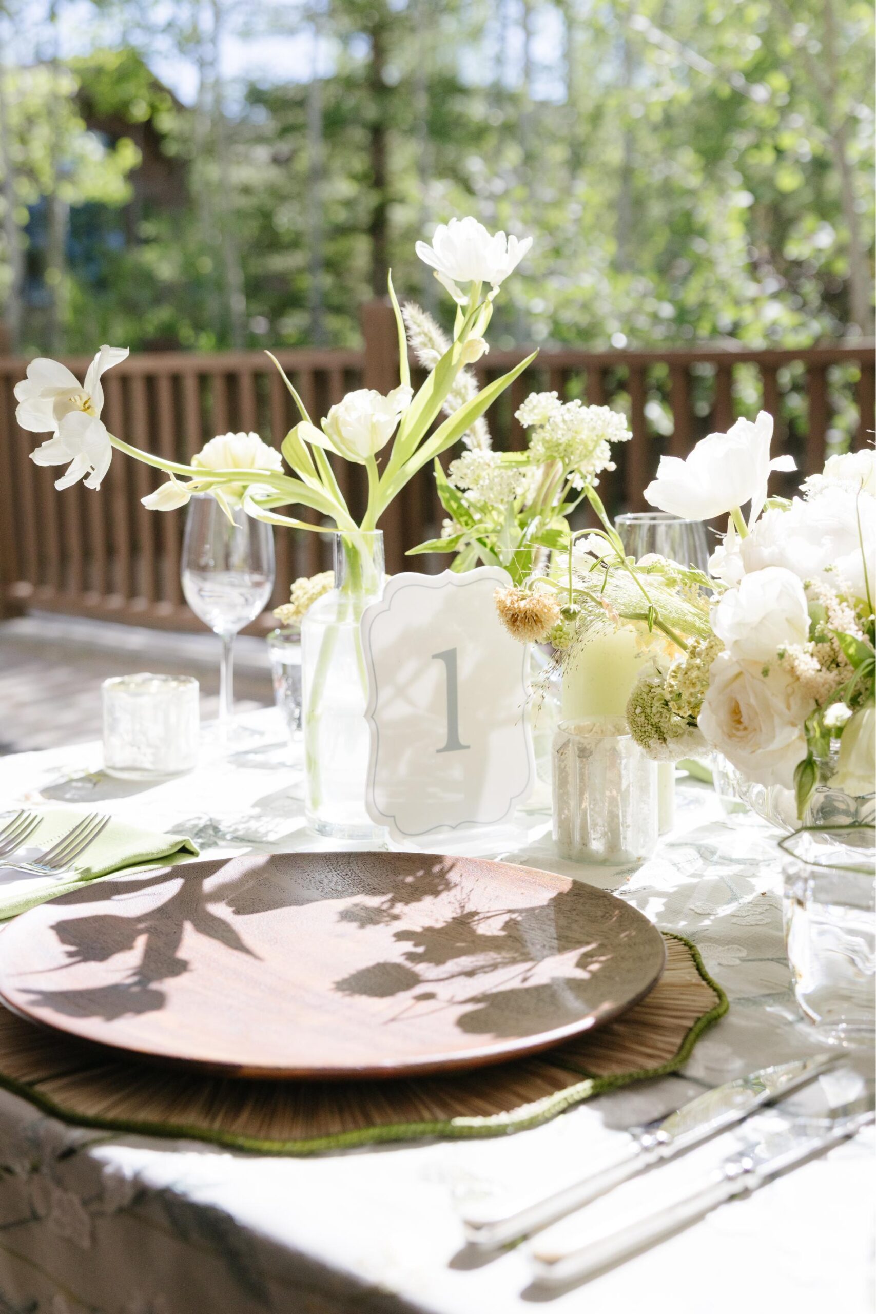 Reception table number surrounded by seasonal flowers with brown, green and white tones.