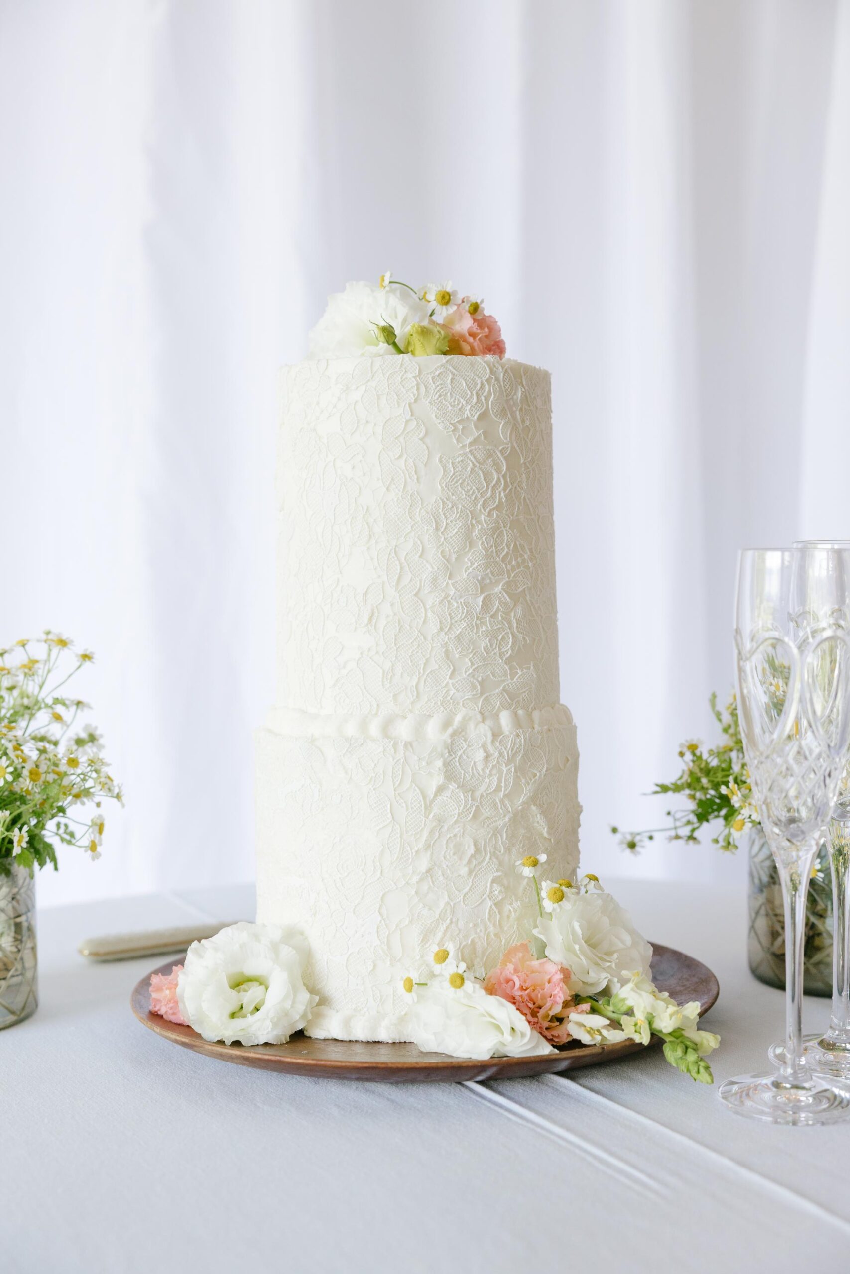 Lace-inspired wedding cake with fresh flowers.
