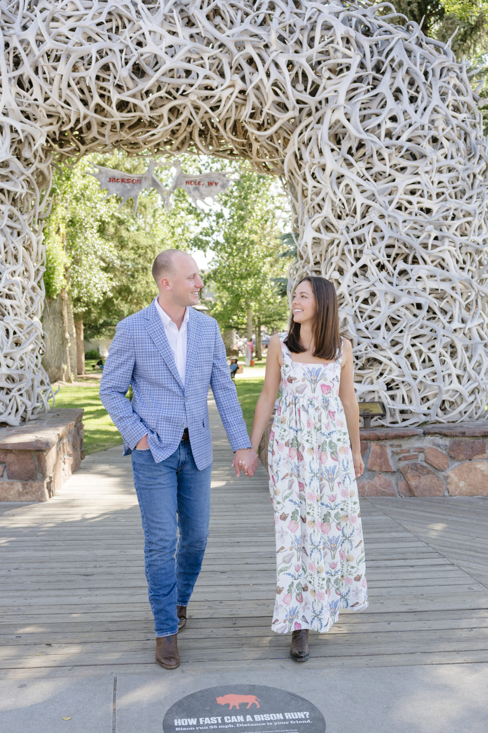 Couple posing beneath the iconic antler arch in Jackson Town Square.