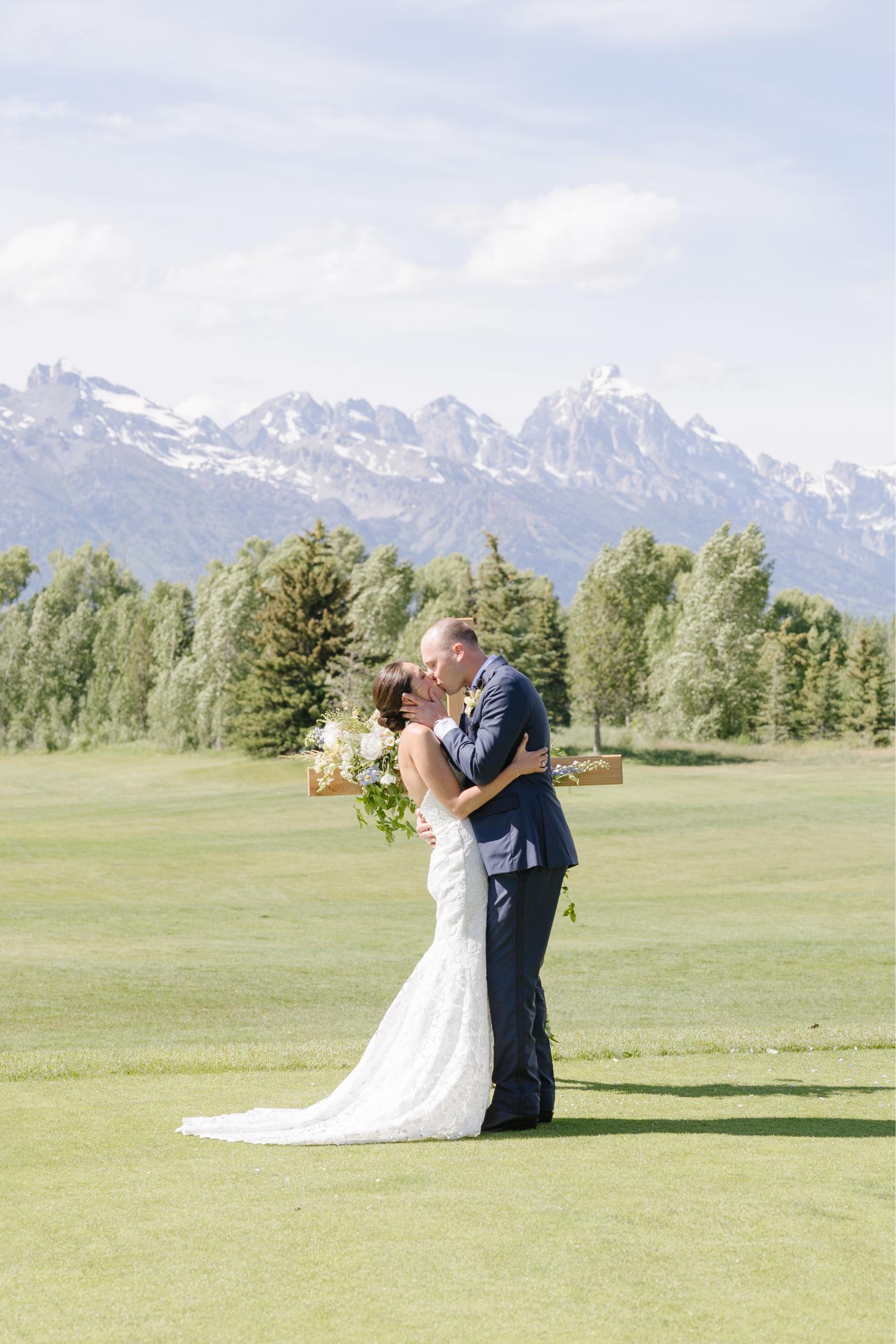 First kiss at a Jackson Hole Golf and Tennis Club wedding with the Teton Range in the background