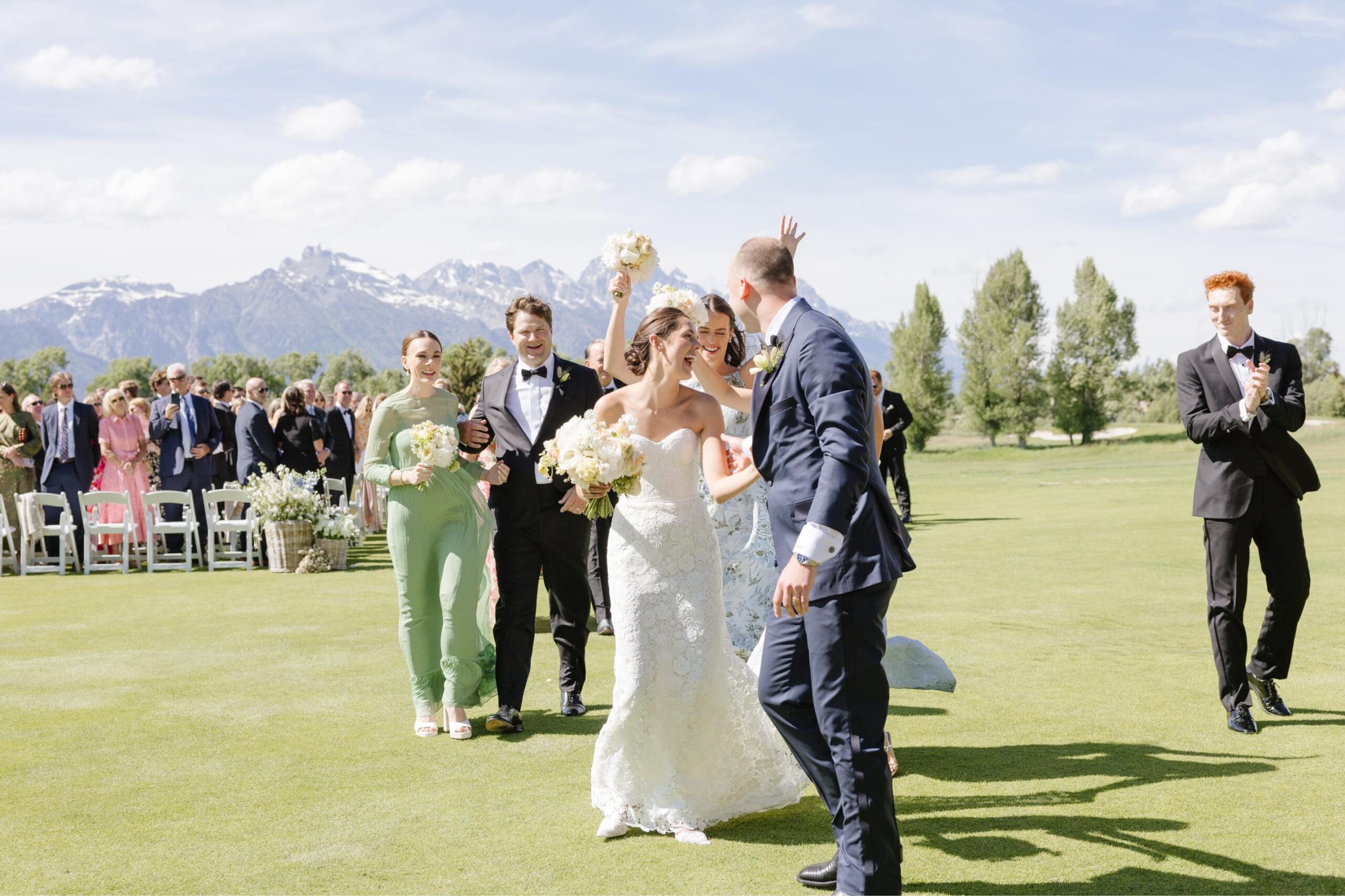 Bride and groom celebrating after their ceremony at a Jackson Hole Golf and Tennis Club wedding.