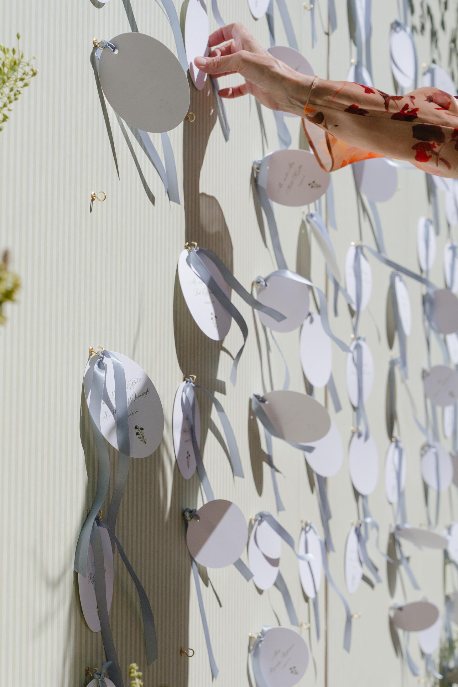 Elegant escort card display with blue ribbon details at a Jackson Hole Golf and Tennis Club wedding reception