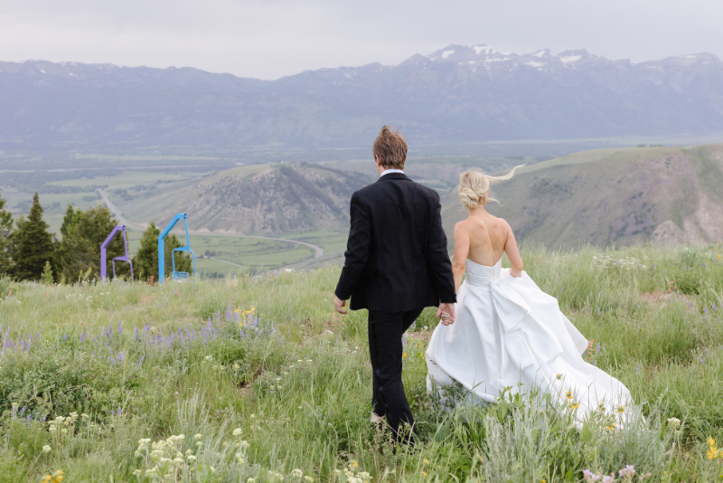 Destination wedding couple walking through a mountain meadow in Jackson Hole