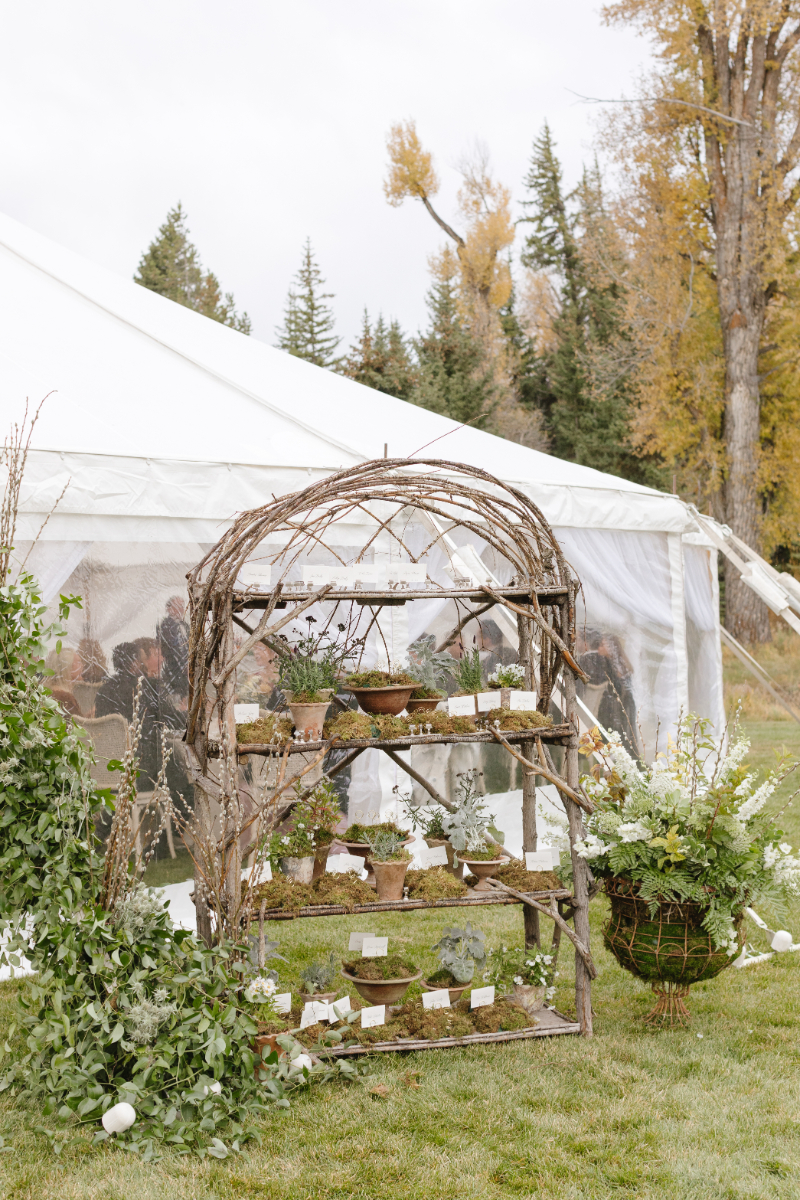 Rustic escort card display outside a fall wedding reception tent in Jackson Hole