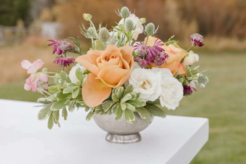 Seasonal floral centerpiece with peach roses for a Jackson Hole fall wedding