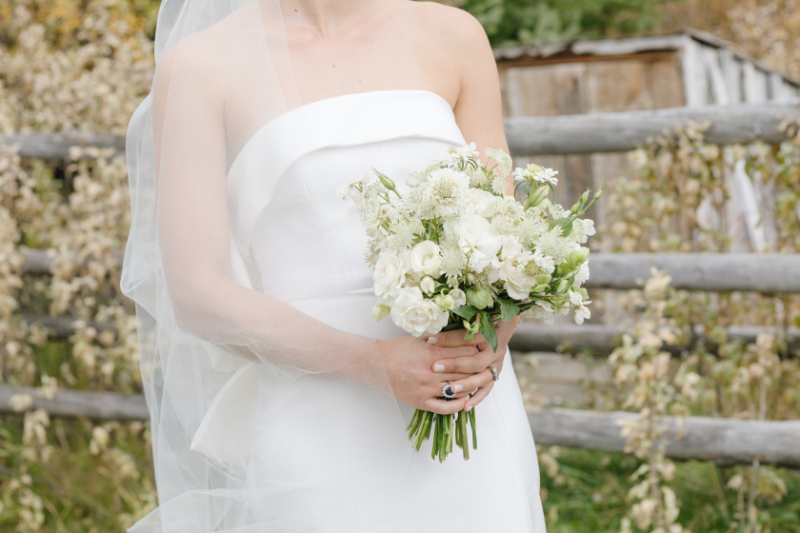 Close up photo of a bride holding a white bouquet during 