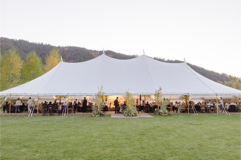 Elegant sailcloth reception tent set up on the lawn at Snake River Sporting Club for a fall wedding