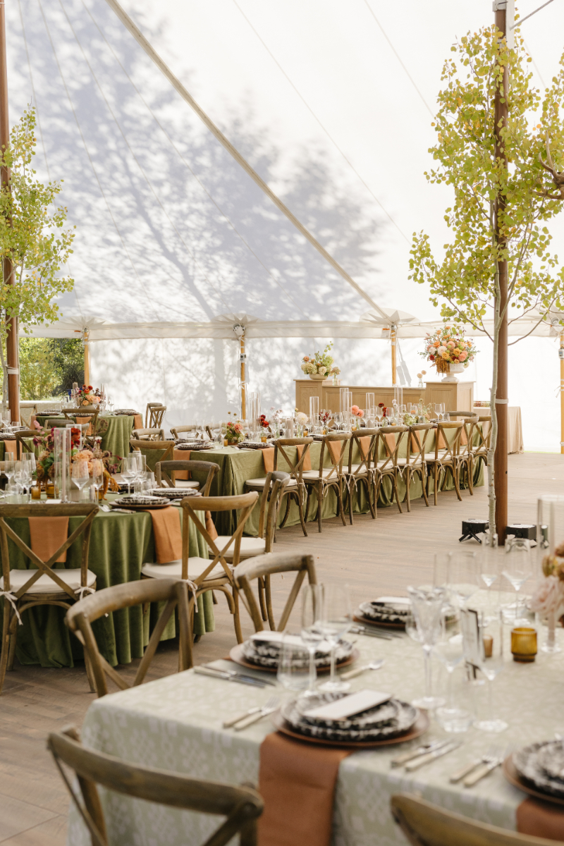 Elegant reception tables with autumn-inspired décor inside the Snake River Sporting Club wedding tent