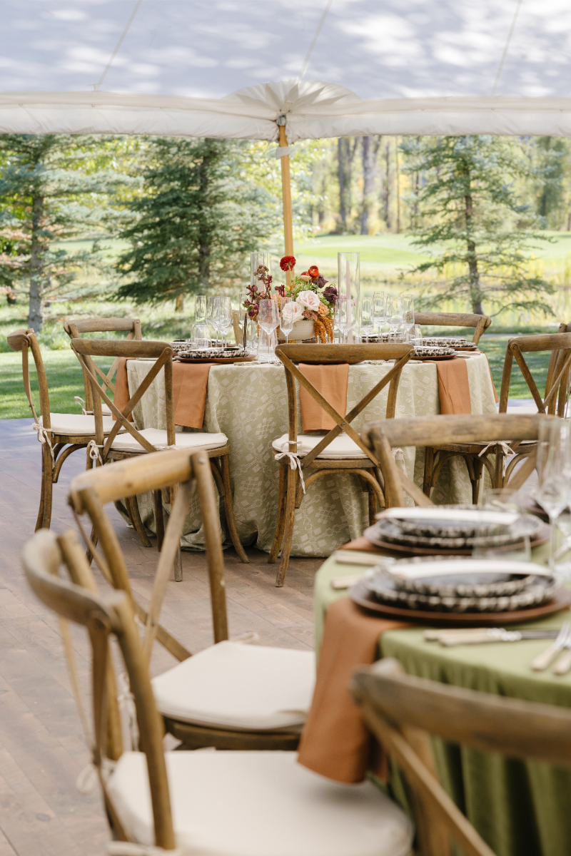 Reception tables overlooking the lawn inside the Snake River Sporting Club wedding tent