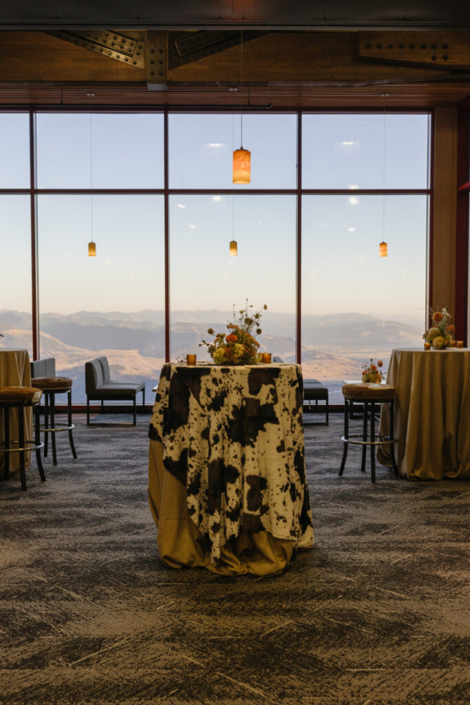 Cocktail tables with mountain views inside Rendezvous Lodge during the Jackson Hole wedding welcome party