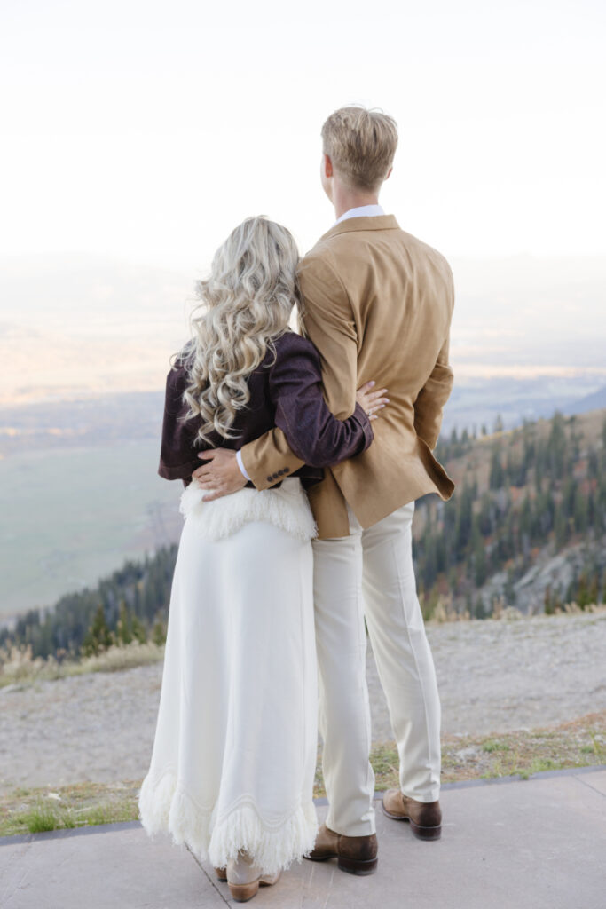 Couple overlooking the Teton Mountains during their welcome party at Jackson Hole Mountain Resort's Rendezvous Lodge
