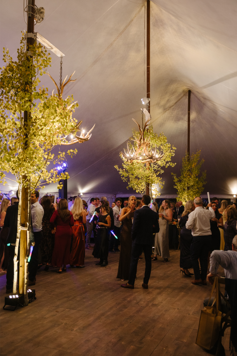 Elegant reception tent with glowing antler chandeliers at Snake River Sporting Club wedding