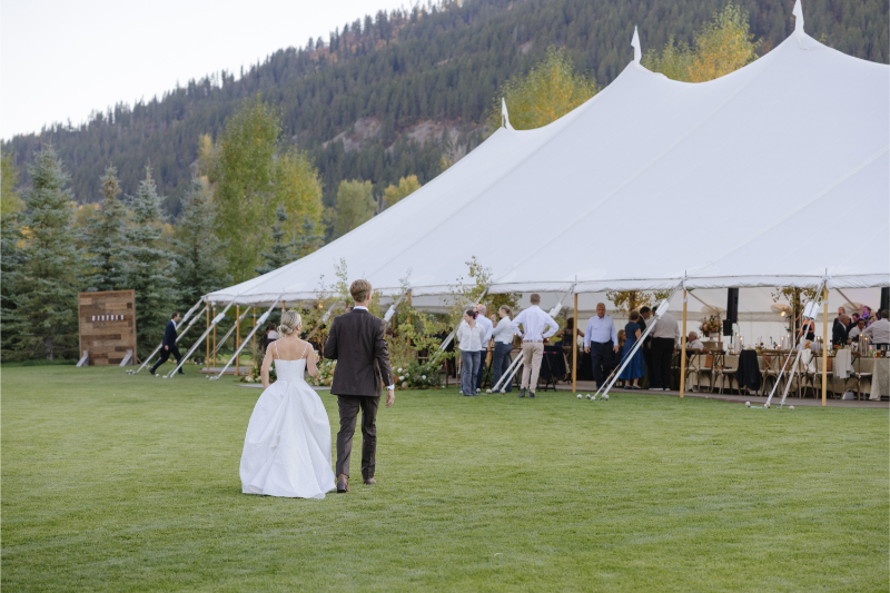 Bride and groom walking toward their reception tent at Snake River Sporting Club after golden hour portraits