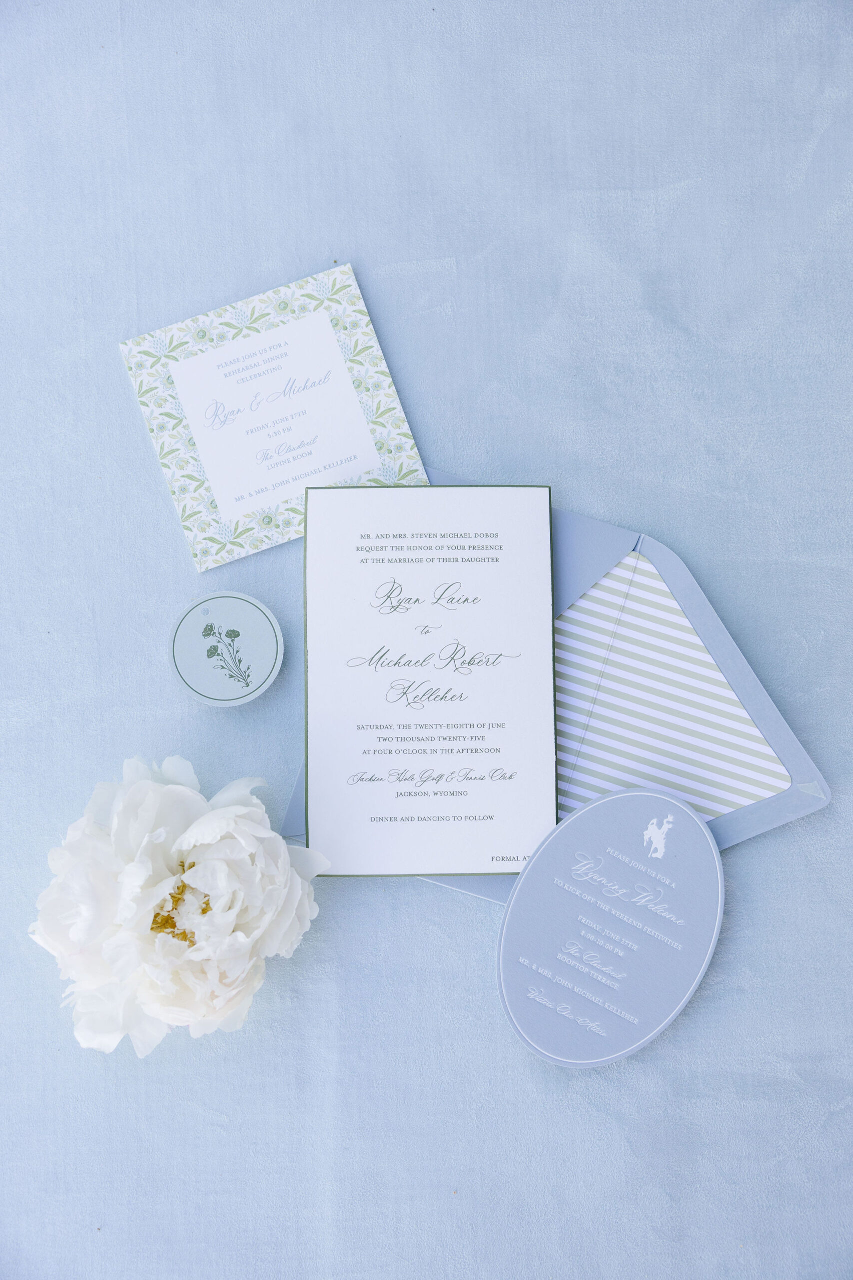Blue and green wedding invitation suite with elegant stationery, striped envelope liner, and white peony.