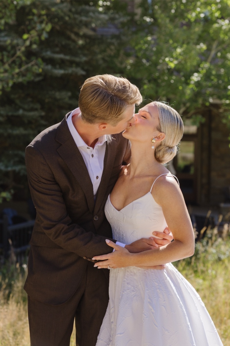Bride and groom share kiss during their first look at Snake River Sporting Club.