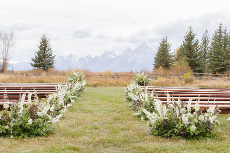Wedding ceremony ideas featuring a flower-lined ceremony aisle with breathtaking Grand Teton mountain views.