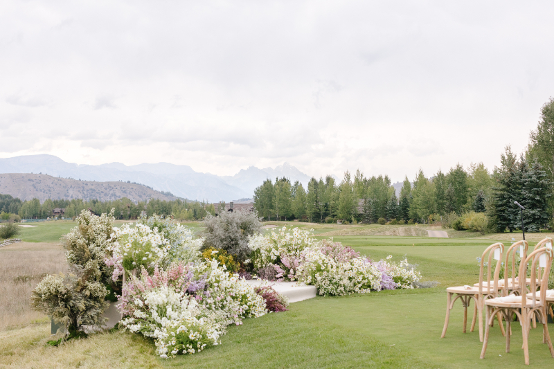 Elegant wedding ceremony ideas with lush floral aisle arrangements and mountain views in Jackson Hole.
