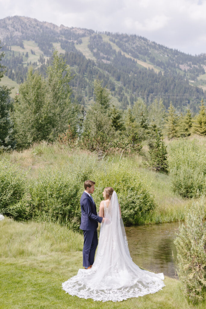 Jackson Hole Wyoming wedding couple standing beside a creek with mountain views