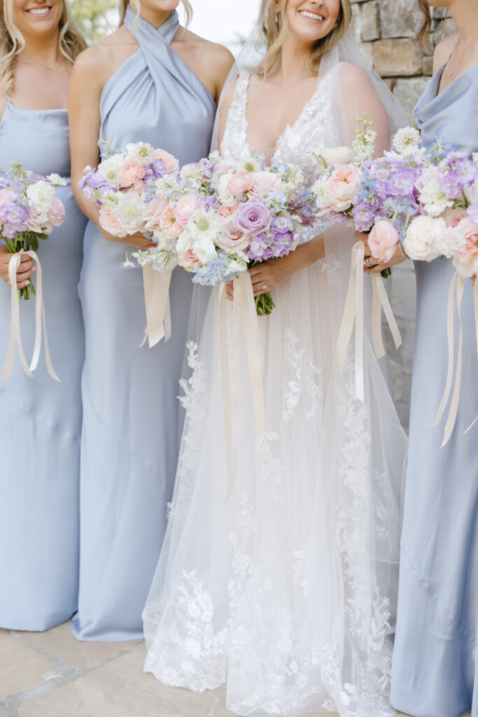 Bride and bridesmaids holding pastel wedding bouquets in Jackson Hole
