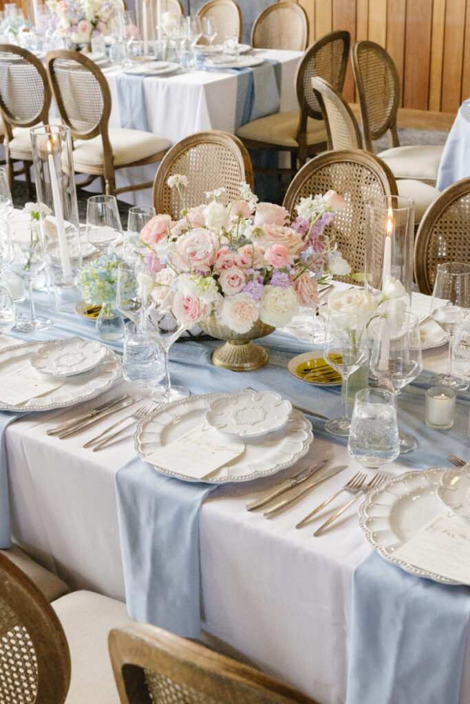 Elegant blue and white wedding tablescape with pastel floral centerpiece