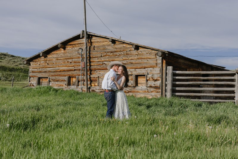 Couple embracing beside a rustic Wyoming ranch near Jackson Hole