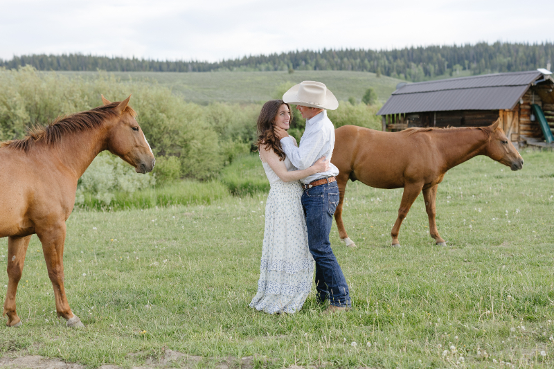 Couple with horses during a romantic Jackson Hole engagement session
