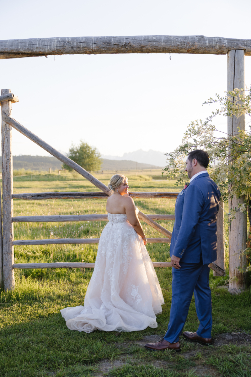 Bride and groom are directed by photographer into wedding picture poses that feel natural for a western wedding.