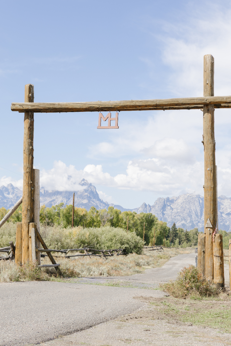 Rustic wooden entrance with the Teton Mountains in the background at Diamond Cross Ranch in Jackson Hole, Wyoming.