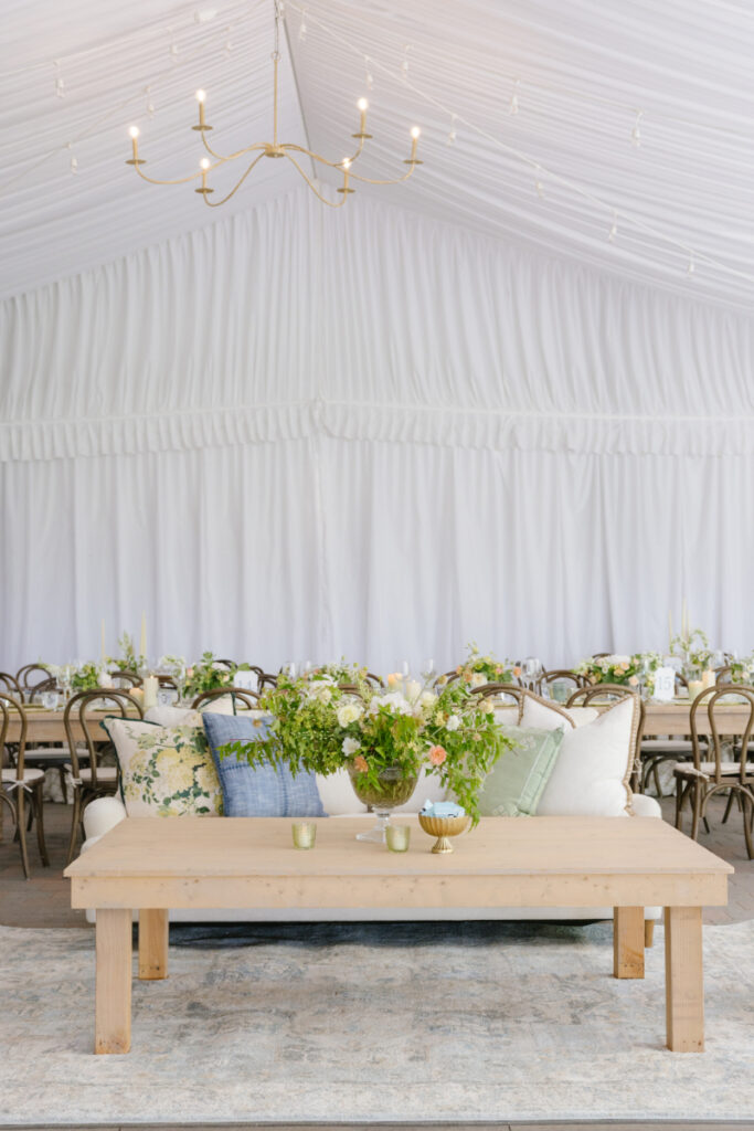 Elegant wedding reception inside a white sailcloth tent with lounge seating and lush floral arrangements in Jackson Hole.