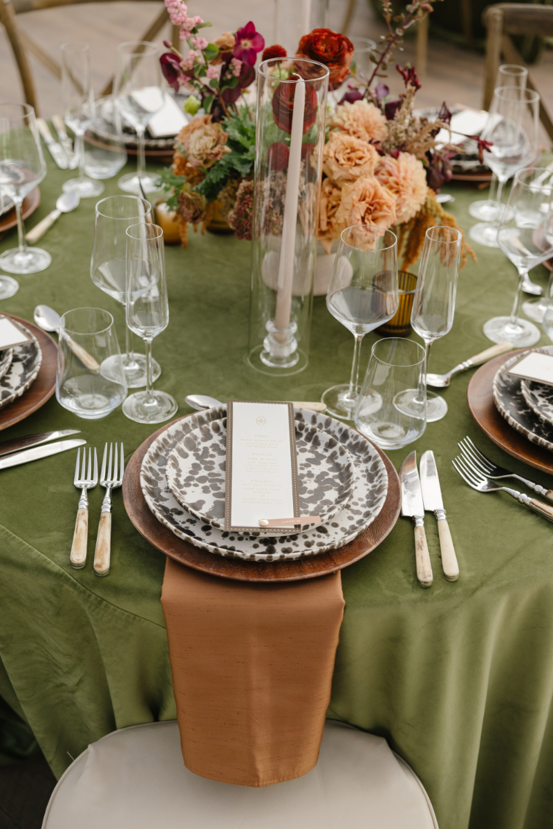 Jackson Lake Lodge wedding table setting with green linens, patterned plates, and autumn floral centerpiece