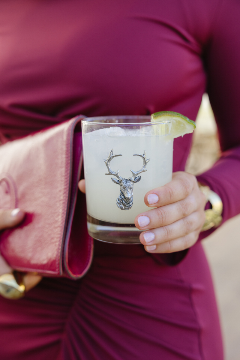 Wedding guest holding a lime cocktail in a stag glass during a Jackson wedding celebration.