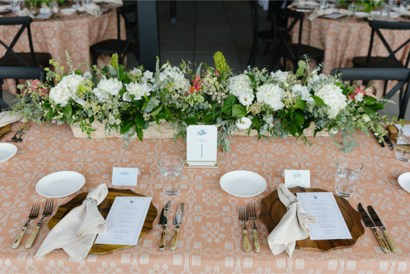 Elegant reception table with white floral centerpiece and patterned linens at a Jackson wedding.